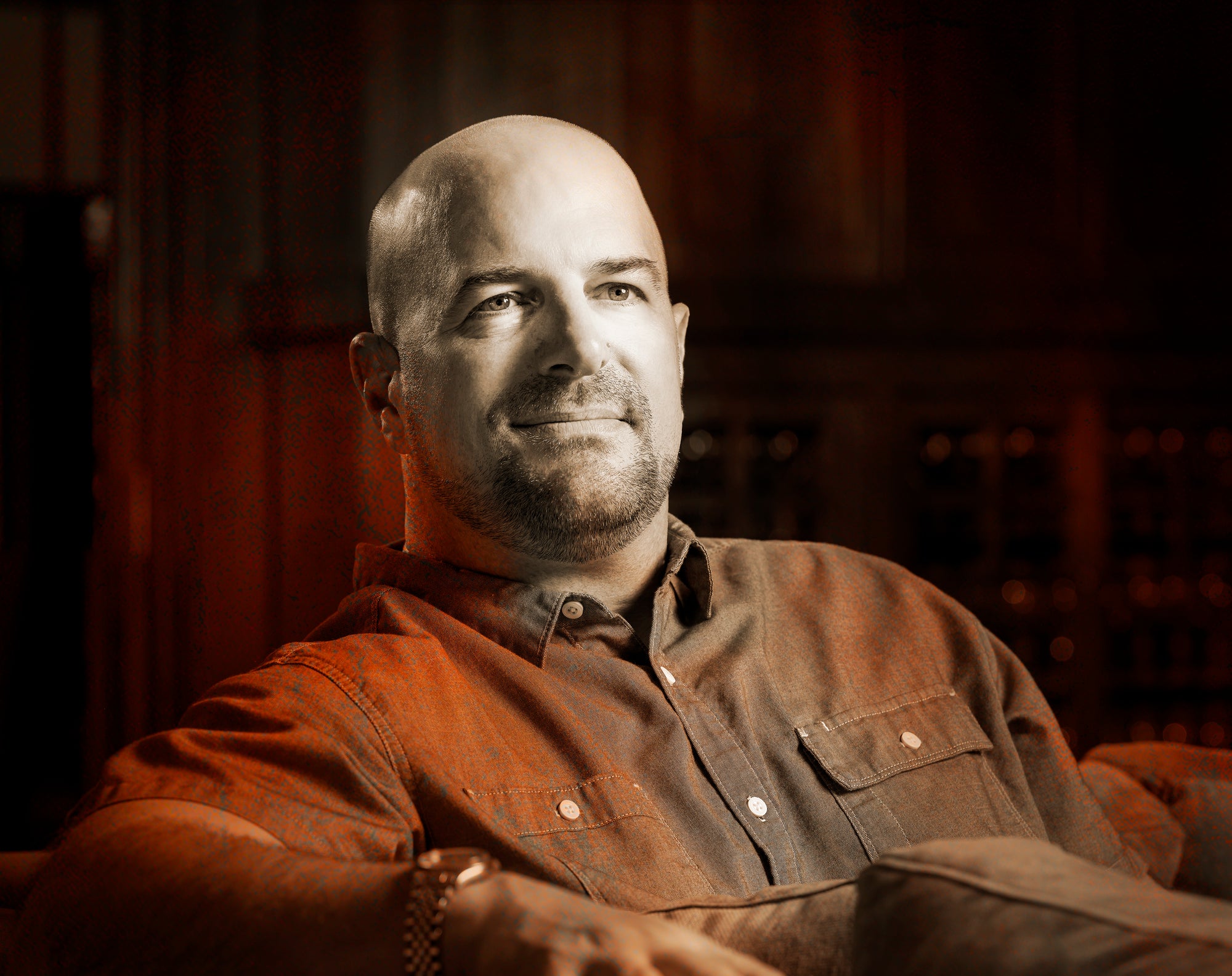 Nate Weis, winemaker for Hewitt Vineyards, sitting in a chair and wearing a brown shirt